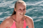 Young blonde female emerging from water