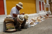 A man sitting amongst his hats for sale on the streets of Cartagena, Colombia