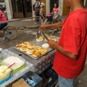 Man in a red t-shirt selling potato cakes from a roadside cart, Cartagena, Colombia