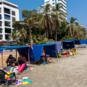 Families sitting in their beach tents on the Plaza Playa de Castillo Grande, Cartagena, Colombia