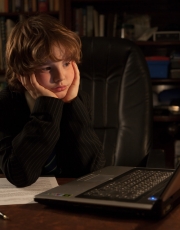 Young business boy in an office studying the laptop computer