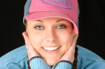 Pretty smiling young woman with good teeth wearing baseball cap